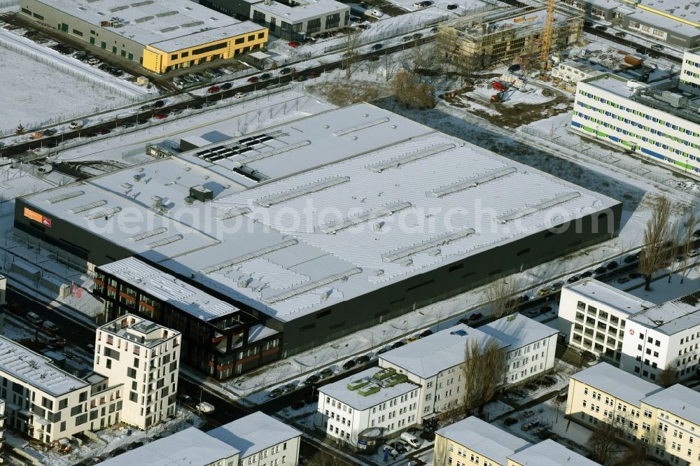 Berlin from above - Wintry snowy warehouse complex-building in the industrial area on Gross-Berliner Damm in Berlin in Germany