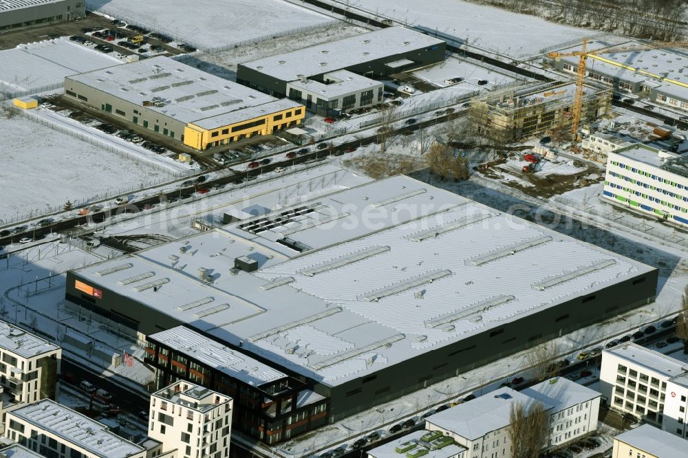 Berlin from the bird's eye view: Wintry snowy warehouse complex-building in the industrial area on Gross-Berliner Damm in Berlin in Germany