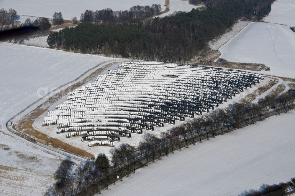 Werneuchen from above - Wintry snowy panel rows of photovoltaic and solar farm or solar power plant in Werneuchen in the state Brandenburg