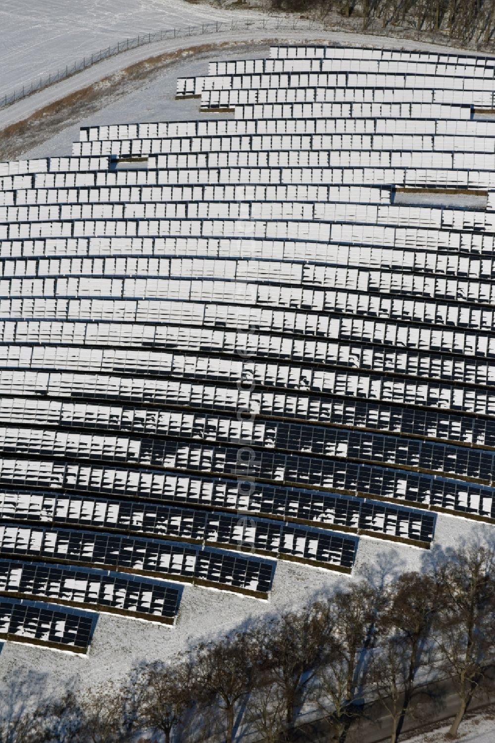 Aerial image Werneuchen - Wintry snowy panel rows of photovoltaic and solar farm or solar power plant in Werneuchen in the state Brandenburg