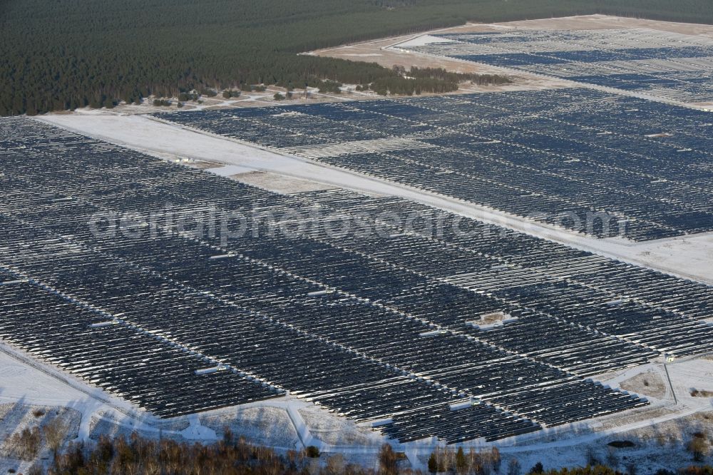 Brandenburg an der Havel from the bird's eye view: Winterly snowy solar park on the former NVA airfield Brandenburg-Briest in Brandenburg an der Havel in the Federal State of Brandenburg. It is a joint project between the company of Q-cells and the investors Luxcara GmbH and the MCG group