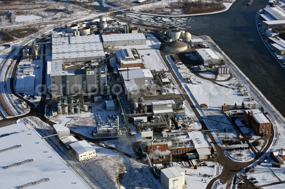 Aerial photograph Genthin - Wintry snow-covered company grounds and facilities of Waschmittelwerk Genthin GmbH (laundry detergent works) in Genthin in the state of Saxony-Anhalt. The works and facilities area located in the Northern industrial park on the riverbank of the Elbe-Havel-Canal and are part of Hansa Group