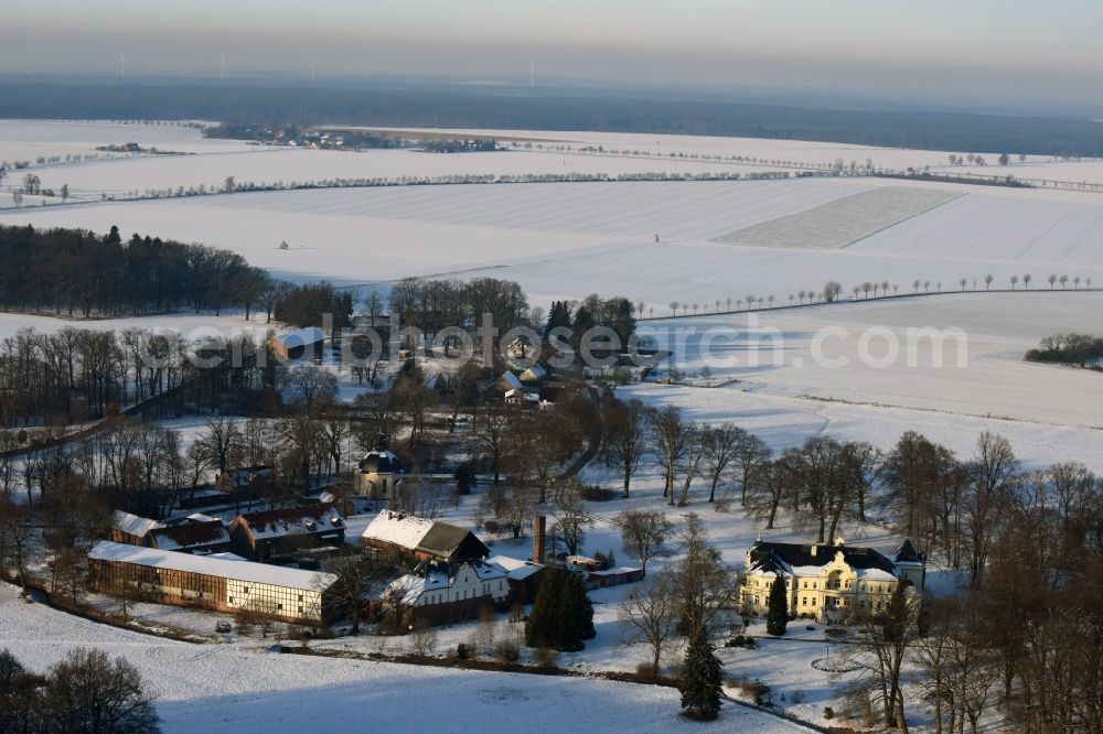 Aerial photograph Krüssau - Winterly snowy buildings and parks at the mansion of the farmhouse Brandenstein in Kruessau in the state Saxony-Anhalt