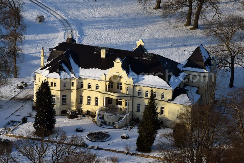 Krüssau from above - Winterly snowy buildings and parks at the mansion of the farmhouse Brandenstein in Kruessau in the state Saxony-Anhalt