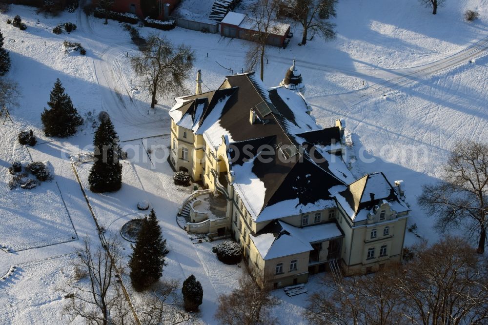 Aerial image Krüssau - Winterly snowy buildings and parks at the mansion of the farmhouse Brandenstein in Kruessau in the state Saxony-Anhalt