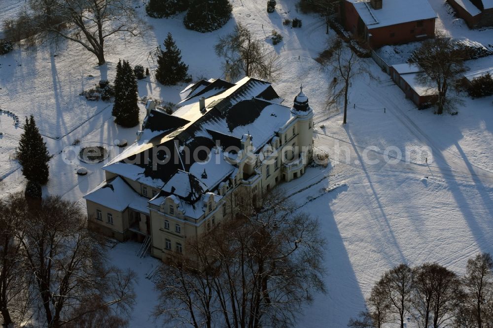 Aerial photograph Krüssau - Winterly snowy buildings and parks at the mansion of the farmhouse Brandenstein in Kruessau in the state Saxony-Anhalt