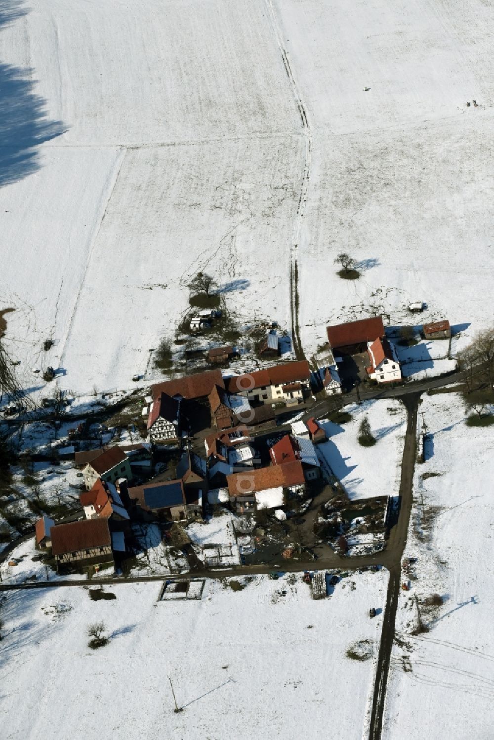 Aerial image Weilar - Wintry snowy Farm on the edge of cultivated fields in Weilar in the state Thuringia