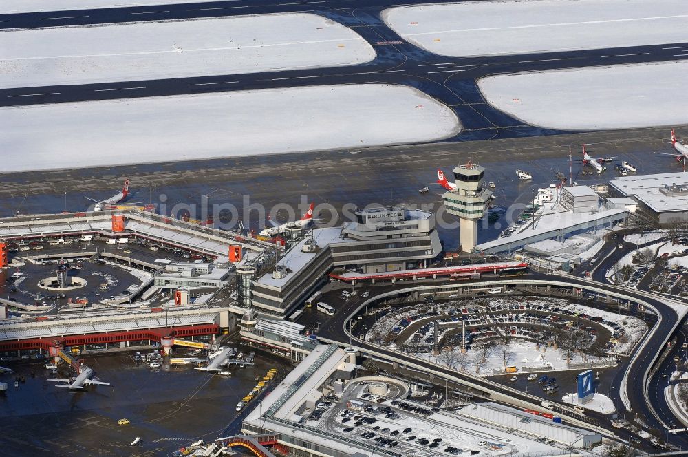 Berlin from above - Wintry snowy Runway with hangar taxiways and terminals on the grounds of the airport in Berlin