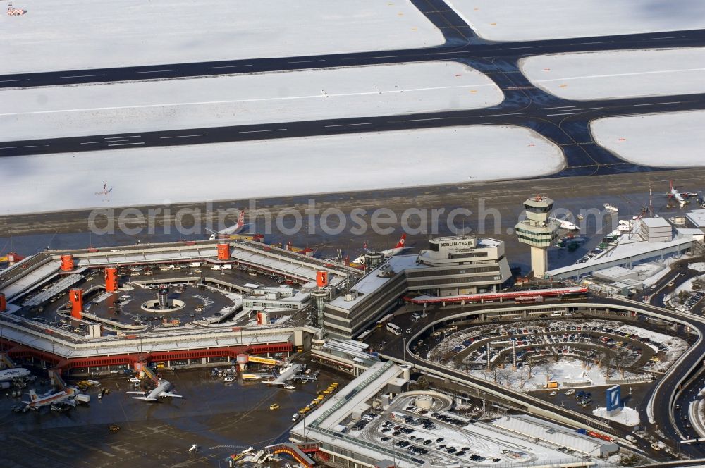 Aerial image Berlin - Wintry snowy Runway with hangar taxiways and terminals on the grounds of the airport in Berlin