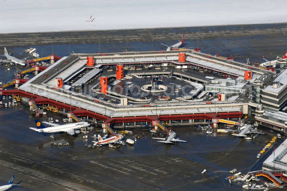 Berlin from above - Wintry snowy Runway with hangar taxiways and terminals on the grounds of the airport in Berlin