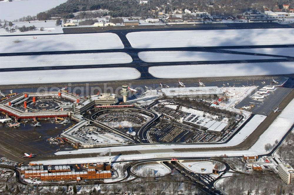 Berlin from above - Wintry snowy Runway with hangar taxiways and terminals on the grounds of the airport in Berlin