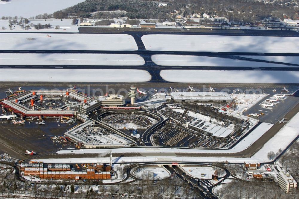 Berlin from the bird's eye view: Wintry snowy Runway with hangar taxiways and terminals on the grounds of the airport in Berlin