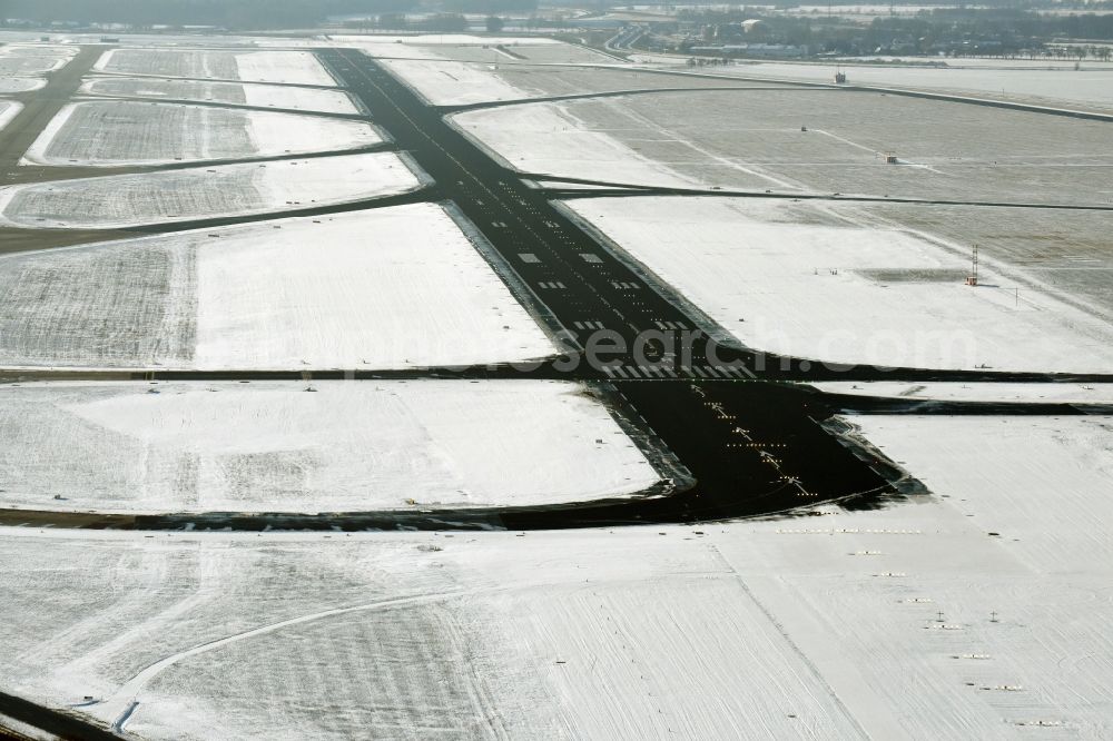 Schönefeld from the bird's eye view: Wintry snowy terrain of the runway - runway of the airport in Schoenefeld in Brandenburg