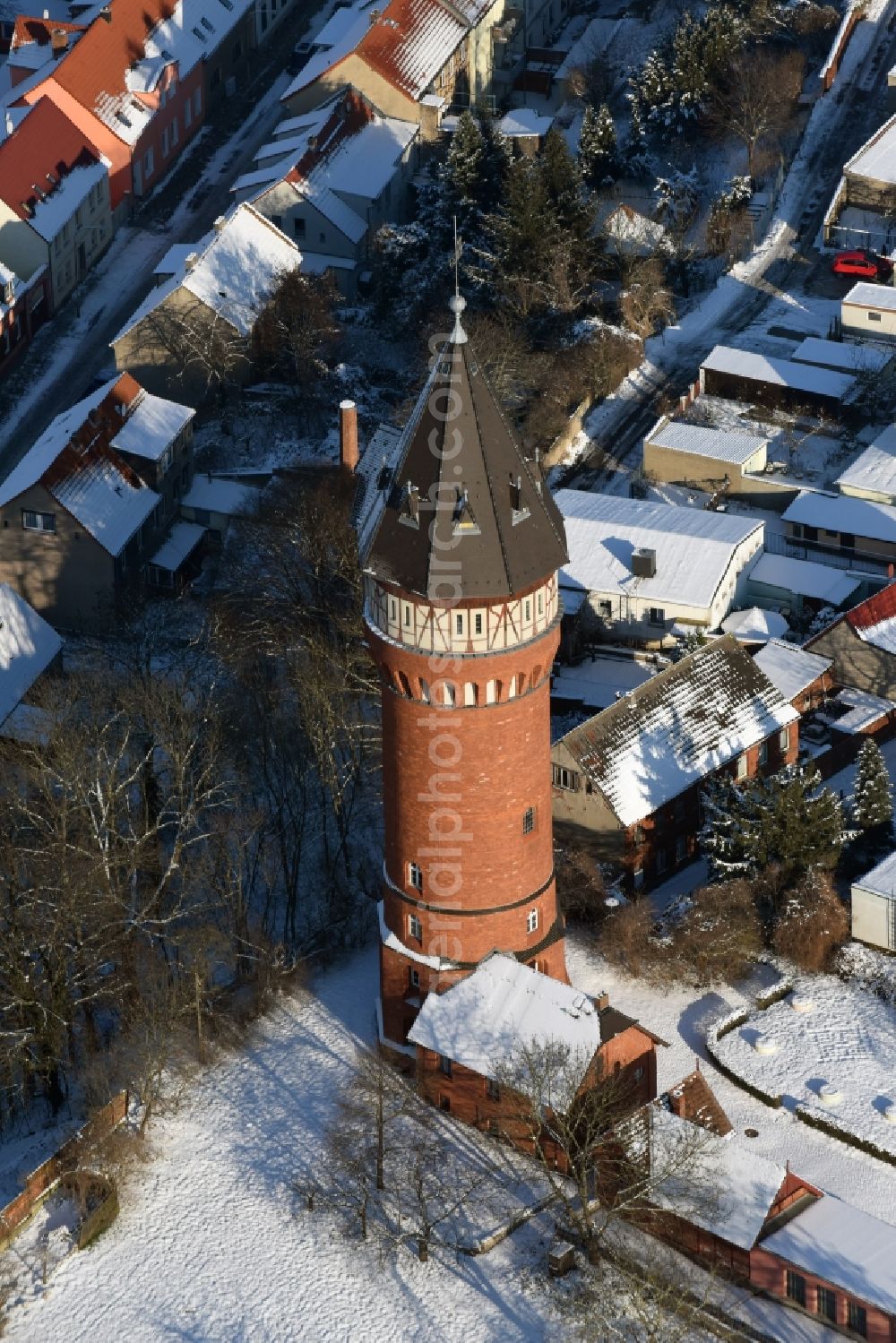 Aerial image Burg - Building of the winterly snowy industrial monument water tower with framework elements in Weinbergstrasse in Burg in the state Saxony-Anhalt