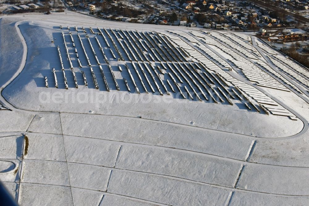 Magdeburg from above - Wintry snowy panel rows of photovoltaic and solar farm or solar power plant am Solarpark auf der ehemaligen Hausmuelldeponie Cracauer Anger in Magdeburg in the state Saxony-Anhalt