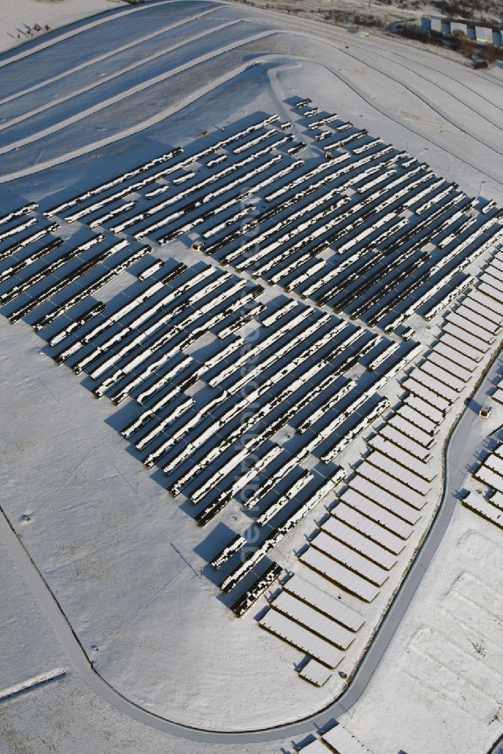 Aerial image Magdeburg - Wintry snowy panel rows of photovoltaic and solar farm or solar power plant am Solarpark auf der ehemaligen Hausmuelldeponie Cracauer Anger in Magdeburg in the state Saxony-Anhalt