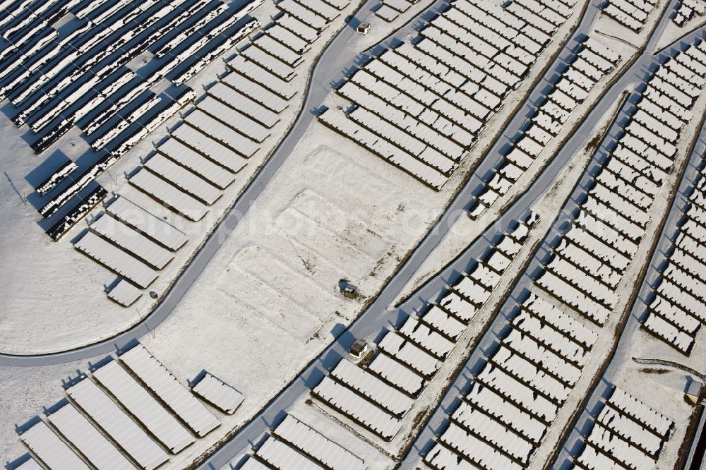 Aerial image Magdeburg - Wintry snowy panel rows of photovoltaic and solar farm or solar power plant am Solarpark auf der ehemaligen Hausmuelldeponie Cracauer Anger in Magdeburg in the state Saxony-Anhalt