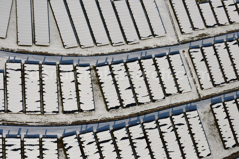 Magdeburg from above - Wintry snowy panel rows of photovoltaic and solar farm or solar power plant am Solarpark auf der ehemaligen Hausmuelldeponie Cracauer Anger in Magdeburg in the state Saxony-Anhalt