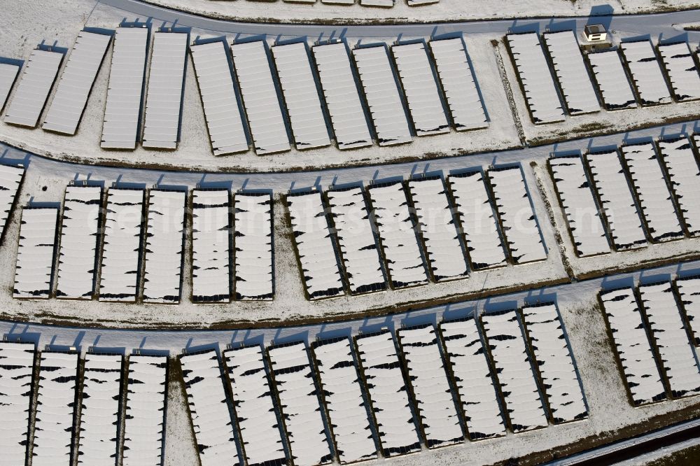 Aerial image Magdeburg - Wintry snowy panel rows of photovoltaic and solar farm or solar power plant am Solarpark auf der ehemaligen Hausmuelldeponie Cracauer Anger in Magdeburg in the state Saxony-Anhalt