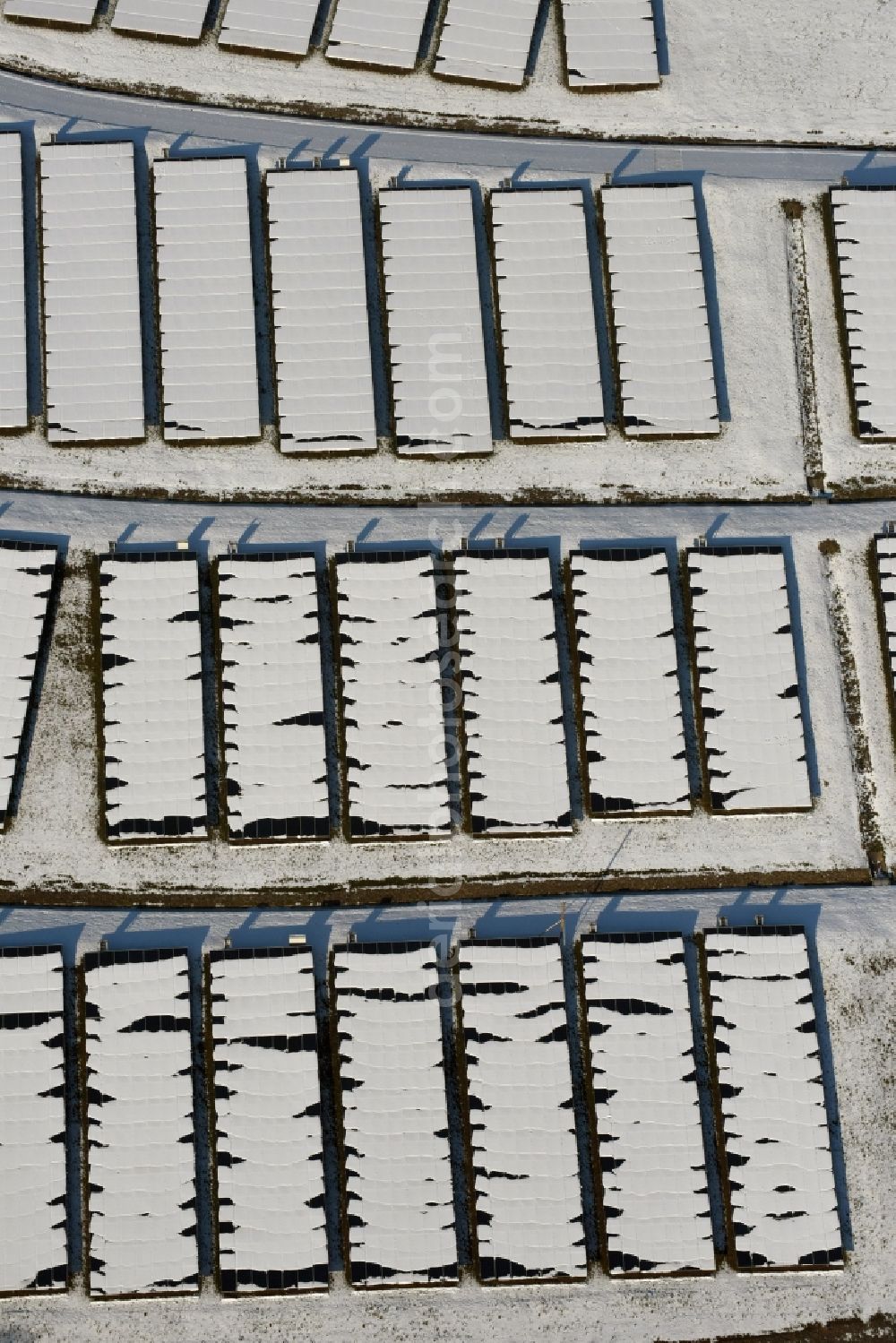 Magdeburg from above - Wintry snowy panel rows of photovoltaic and solar farm or solar power plant am Solarpark auf der ehemaligen Hausmuelldeponie Cracauer Anger in Magdeburg in the state Saxony-Anhalt