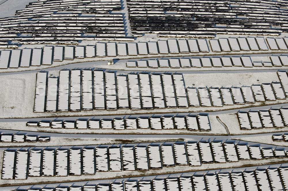 Aerial photograph Magdeburg - Wintry snowy panel rows of photovoltaic and solar farm or solar power plant am Solarpark auf der ehemaligen Hausmuelldeponie Cracauer Anger in Magdeburg in the state Saxony-Anhalt