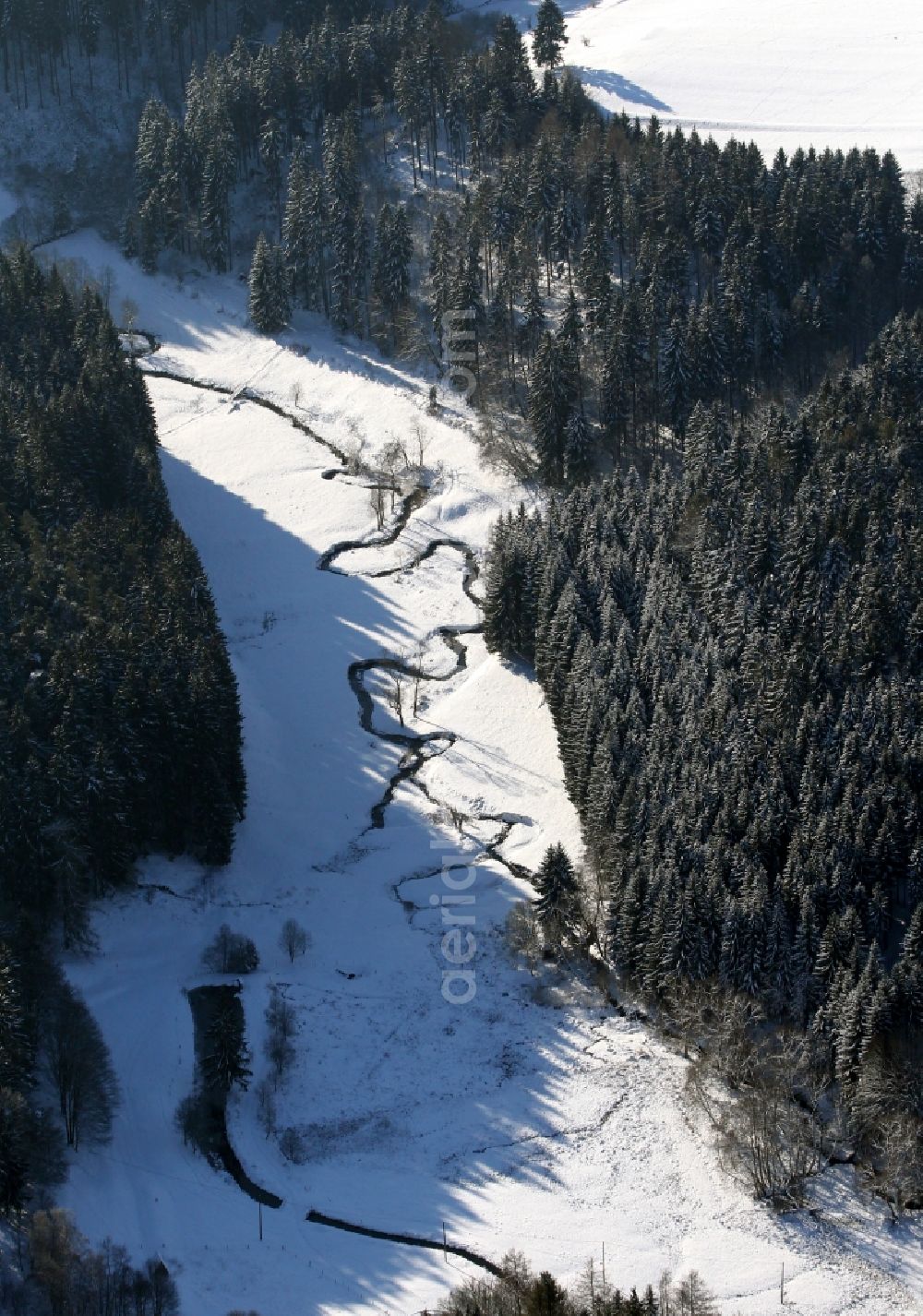 Aerial photograph grossbreitenbach - Snow-covered valley of a creek in a wintry forest in Grossbreitenbach in the state of Thuringia