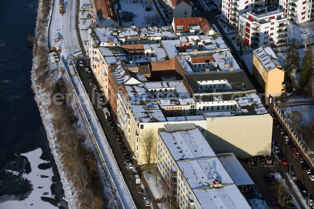 Aerial image Magdeburg - Winterly snowy residential area of a multi-family house settlement right at the water's edge of Elbe in Zollstrasse in Magdeburg in the state Saxony-Anhalt