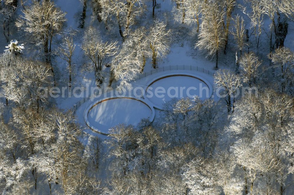 Aerial image Potsdam - Blick auf das winterlich vereiste und verscheite Achterbecken im Babelsberger Park. Nach jahrzehntelangen Verfall der Anlage am ehemaligen Grenzstreifen wurde der Wasserspeicher 2008 fertig restauriert und zum Betrieben der Fontaine auf dem Tiefen See nutzbar gemacht. Bereits im Mai 1845 konnte die erste Fontänenanlage am Babelsberger Park eingeweiht werden. Durch den Anbau einer neuen Maschinenhalle 1865, stand eine Dampfkraft von 65 PS für die Bewässerung des Parks zur Verfügung. Zu einem besonderen Schauspiel wurde die 40 Meter hohe Fontäne, die wie ein Geysir aus der Havel emporschoss. Nach dem Bau des Achterbecken erhielt die Parkanlage eine ausreichende Wasserversorgung.