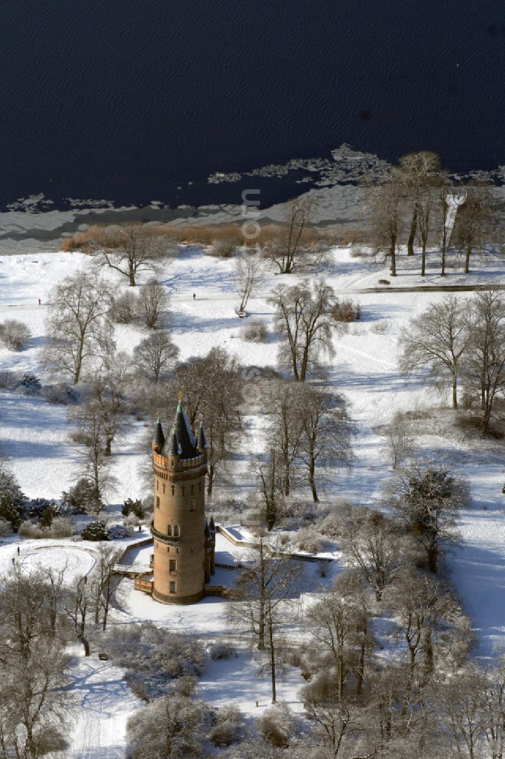 Aerial photograph POTSDAM - Blick auf den winterlich verschneiten Flatowturm im Park Babelsberg. Der Turm wurde in den Jahren 1853-1856 nach Plänen des Architekten Strack und unter der Leitung von Martin Gottgetreu errichtet. Der Flatowturm ist ein 46 Meter hoher Wohnturm. Kontakt: Stiftung Preußische Schlösser und Gärten Berlin-Brandenburg, 14414 Potsdam, Tel. 0331 9694 0, Fax 0331 9694 107