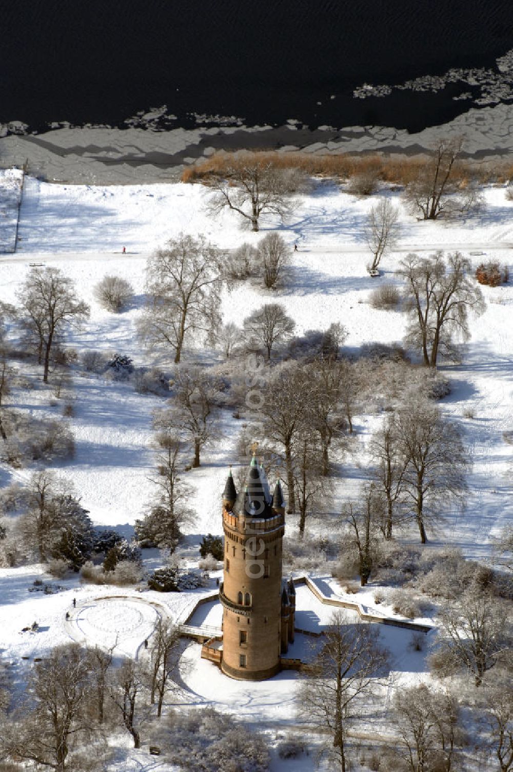 POTSDAM from above - Blick auf den winterlich verschneiten Flatowturm im Park Babelsberg. Der Turm wurde in den Jahren 1853-1856 nach Plänen des Architekten Strack und unter der Leitung von Martin Gottgetreu errichtet. Der Flatowturm ist ein 46 Meter hoher Wohnturm. Kontakt: Stiftung Preußische Schlösser und Gärten Berlin-Brandenburg, 14414 Potsdam, Tel. 0331 9694 0, Fax 0331 9694 107