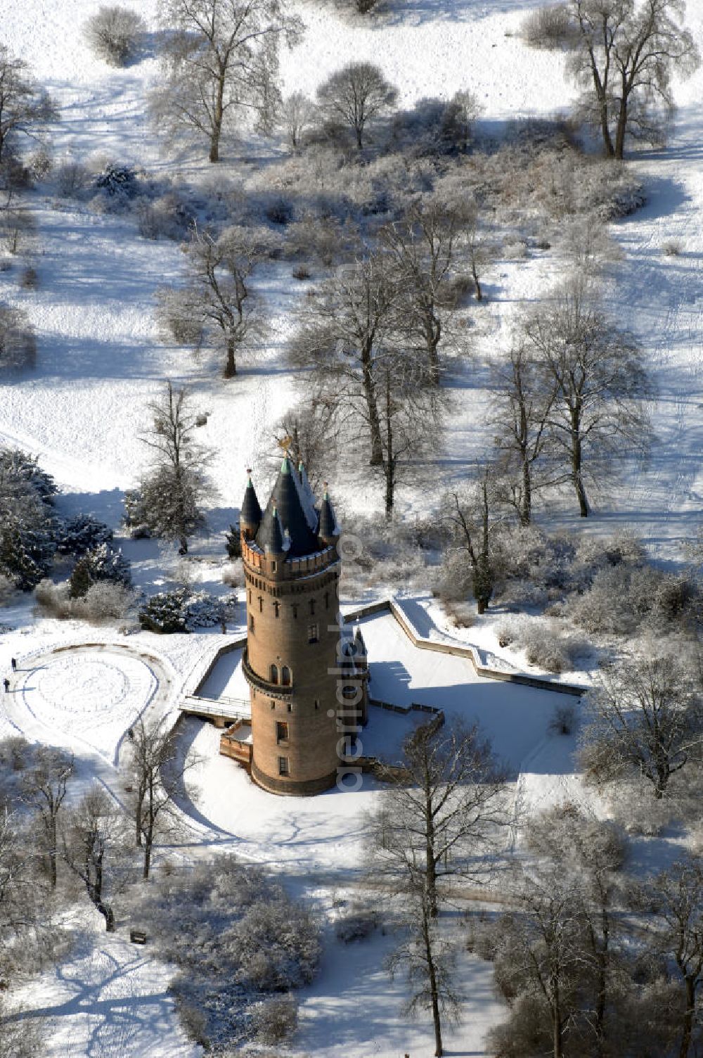 POTSDAM from the bird's eye view: Blick auf den winterlich verschneiten Flatowturm im Park Babelsberg. Der Turm wurde in den Jahren 1853-1856 nach Plänen des Architekten Strack und unter der Leitung von Martin Gottgetreu errichtet. Der Flatowturm ist ein 46 Meter hoher Wohnturm. Kontakt: Stiftung Preußische Schlösser und Gärten Berlin-Brandenburg, 14414 Potsdam, Tel. 0331 9694 0, Fax 0331 9694 107