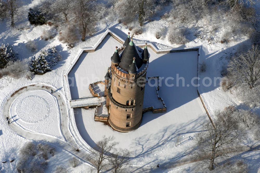 Aerial photograph POTSDAM - Blick auf den winterlich verschneiten Flatowturm im Park Babelsberg. Der Turm wurde in den Jahren 1853-1856 nach Plänen des Architekten Strack und unter der Leitung von Martin Gottgetreu errichtet. Der Flatowturm ist ein 46 Meter hoher Wohnturm. Kontakt: Stiftung Preußische Schlösser und Gärten Berlin-Brandenburg, 14414 Potsdam, Tel. 0331 9694 0, Fax 0331 9694 107