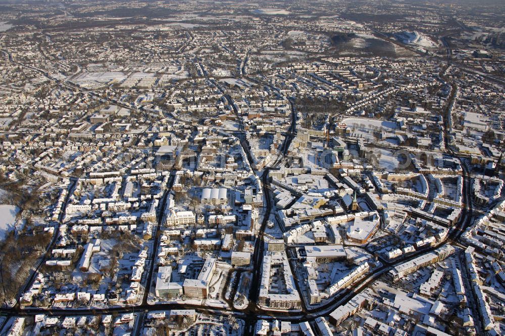 Aerial image Bottrop - Blick auf die winterlich verschneite Innenstadt von Bottrop in Nordrhein-Westfalen. Die Bauarbeiten am ZOB wurden im Oktober 2010 beendet. Die zentral gelegene Liebfrauenkirche steht unter Denkmalschutz. View of the wintry, snowy inner city of Bottrop in North Rhine-Westphalia. The construction on the central bus station was completed in October 2010. The centrally located Liebfrauen church is a listed building.