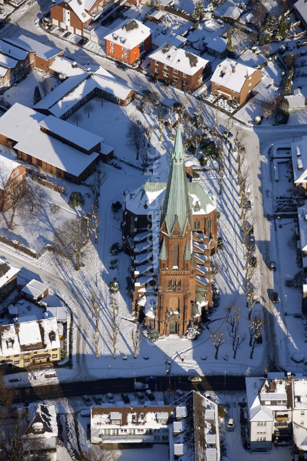 Aerial photograph Bottrop - Blick auf die winterlich verschneite Liebfrauenkirche in Bottrop-Eigen, Nordrhein-Westfalen. Der Bau begann 1908 und wurde 1914 fertig gestellt. Der Kirchturm ist 78 Meter hoch und die Kirche steht unter Denkmalschutz. View of the snowy wintry Liebfrauen church in Bottrop-Eigen, North Rhine Westphalia. Construction began in 1908 and was completed in 1914. The church tower is 78 meters high and the church is a listed building