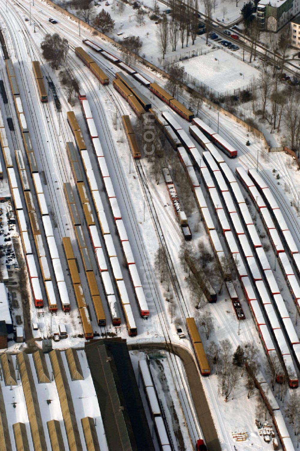 Berlin from the bird's eye view: Blick auf die winterlich verschneite Areal der Abstellgleise vor den Reparaturhallen der S-Bahn-Hauptwerkstatt / Bahnbetriebswerk in Berlin-Schöneweide. Wintry, snowy area of the sidings from the halls of repairing S-Bahn main workshop / depot in Berlin-Schoeneweide.