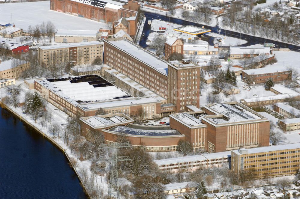 Aerial photograph Berlin - Blick auf das winterlich verschneite Rundfunkzentrum Nalepastrasse. Es zählt zu den bedeutensten Funkbauten der DDR. Hier wurden Maßstäbe für die Rundfunkkultur gesetzt. Dieses mächtige Medium war sowohl Propagandamittel im Kampf der Systeme und Mittel zur Darstellung nach außen als auch nicht zu unterschätzender Kulturträger in der Gesellschaft der DDR. Es ist fast vollständig - bis auf die elektronische Einrichtung - im Zustand der Erbauungszeit erhalten. Man findet hier zum Beispiel Musikaufnahme- und Hörspielstudios. Wegen ihrer sehr guten akustischen Eigenschaften sind die Studios und die Aufnahmesäle für jede Art von Tonaufnahmen auch heute noch nutzbar. Zur Zeit steht das Gebäude leer.