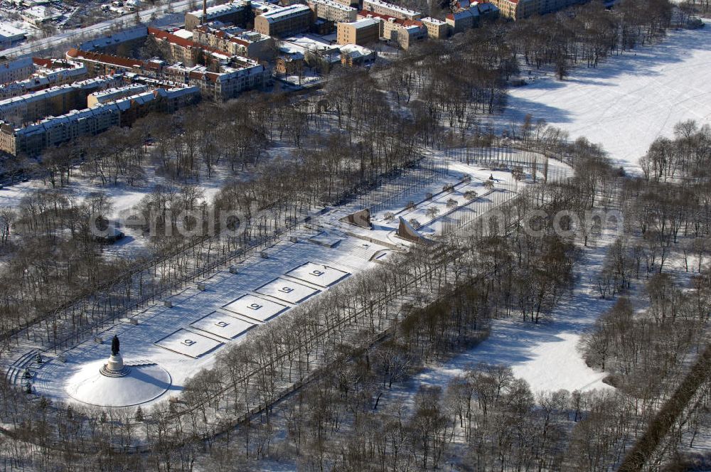 Berlin from above - Blick auf das winterlich verschneite russische Ehrenmal in Berlin Treptow. Zur Gestaltung der Gedenkstätte wurde von den sowjetischen Besatzungstruppen ein Wettbewerb ausgelobt. Von Juni 1946 an wurde ein unter 52 eingereichten Entwürfen ausgewählter Vorschlag umgesetzt. Er stammt von einem sowjetischen „Schöpferkollektiv“, dem der Architekt Jakow S. Belopolski, der Bildhauer Jewgeni Wutschetitsch, der Maler Alexan der A. Gorpenko und die Ingenieurin Sarra S. Walerius vorstanden. Die Gedenkstätte wurde an Stelle der dort vorhandenen großen Spiel- und Sportwiese angelegt, im Mai 1949 wurde die Anlage vollendet.Im Oktober 2003 wurde die Statue des Rotarmisten in einer Werkstatt auf Rügen restauriert, mit einem Schiff wieder nach Berlin gebracht, und steht seit dem 4. Mai 2004 wieder auf ihrem Sockel.