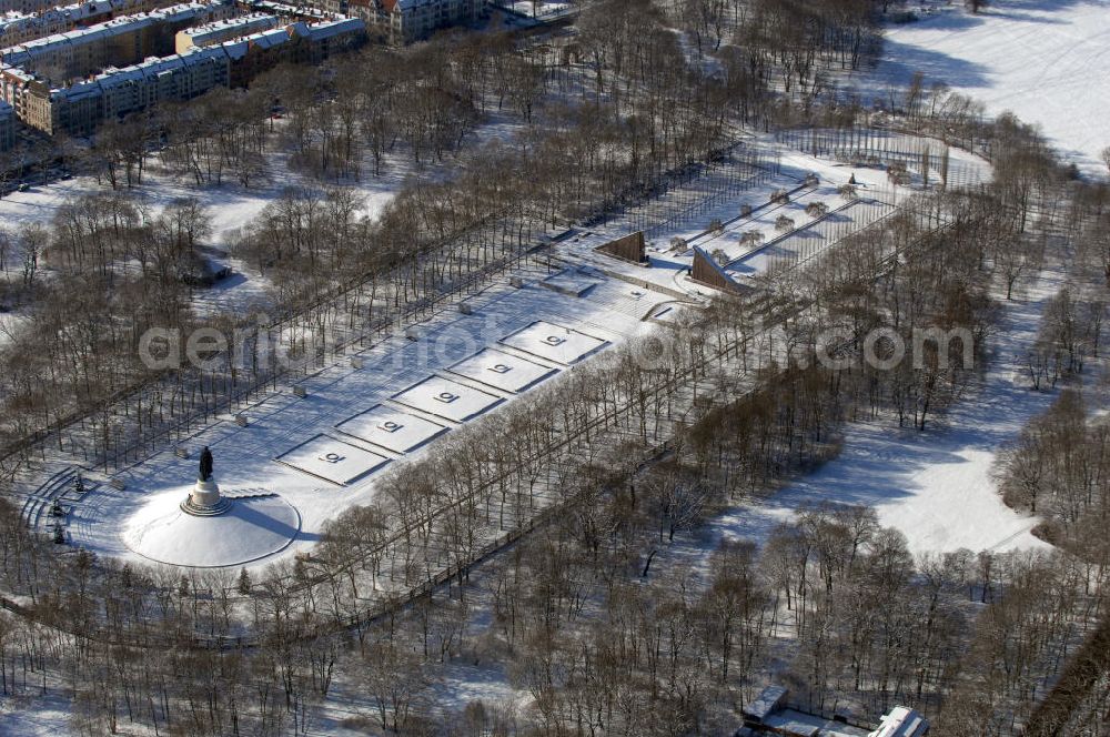 Berlin from the bird's eye view: Blick auf das winterlich verschneite russische Ehrenmal in Berlin Treptow. Zur Gestaltung der Gedenkstätte wurde von den sowjetischen Besatzungstruppen ein Wettbewerb ausgelobt. Von Juni 1946 an wurde ein unter 52 eingereichten Entwürfen ausgewählter Vorschlag umgesetzt. Er stammt von einem sowjetischen „Schöpferkollektiv“, dem der Architekt Jakow S. Belopolski, der Bildhauer Jewgeni Wutschetitsch, der Maler Alexan der A. Gorpenko und die Ingenieurin Sarra S. Walerius vorstanden. Die Gedenkstätte wurde an Stelle der dort vorhandenen großen Spiel- und Sportwiese angelegt, im Mai 1949 wurde die Anlage vollendet.Im Oktober 2003 wurde die Statue des Rotarmisten in einer Werkstatt auf Rügen restauriert, mit einem Schiff wieder nach Berlin gebracht, und steht seit dem 4. Mai 2004 wieder auf ihrem Sockel.