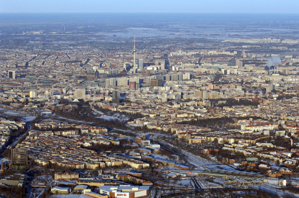 Aerial photograph Berlin - Winterlich verschneite Stadtansicht von Berlin mit Blick auf die Stadtbezirke Neukölln, Kreuzberg und Mitte. Im Vordergrund das Areal des S-Bahnhof Südkreuz.