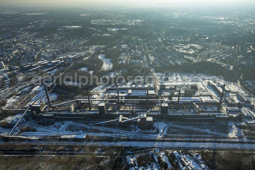 Essen from the bird's eye view: Winterly and snow-covered coal mine industrial complex Zollverein in Essen in the state of North Rhine-Westphalia. Mining activities took place from 1851 until 1986. It has been inscribed into the UNESCO list of World Heritage Sites - together with the adjacent Zollverein Coking Plant - since 2001 and is one of the anchor points of the European Route of Industrial Heritage