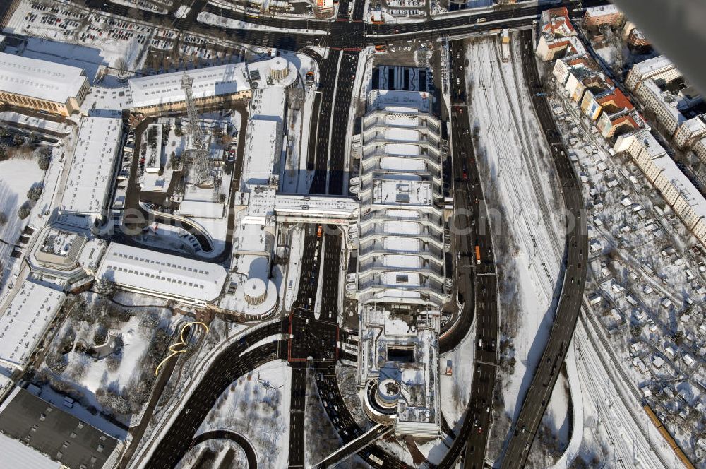 Aerial photograph Berlin - Blick auf den winterlich verschneiten Funkturm am Messegelände mit dem Internationale Congress Centrum Berlin (ICC Berlin) im Ortsteil Westend des Berliner Bezirks Charlottenburg-Wilmersdorf ist eines der größten Kongresshäuser der Welt. Das 320 Meter lange, 80 Meter breite und 40 Meter hohe Gebäude wurde nach Plänen der Berliner Architekten Ralf Schüler und Ursulina Schüler-Witte erbaut und nach nur vier Jahren Bauzeit 1979 eröffnet. Es zählt zu den bedeutendsten Bauwerken der deutschen Nachkriegszeit und kostete über 924 Mio. DM (rd. 473 Mio. Euro). Bis heute dient es als Vorbild für viele Neubauten von Kongresszentren in aller Welt.