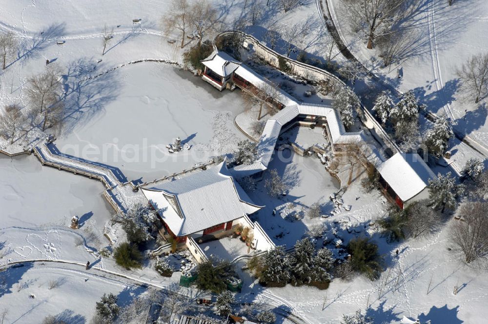 Berlin from above - Blick auf den winterlich verschneiten Chinesischen Garten im Erholungspark Marzahn. Der Erholungspark Marzahn liegt im Berliner Bezirk Marzahn-Hellersdorf am nördlichen Fuß des Kienbergs und wurde am 9. Mai 1987 anlässlich der 750-Jahr-Feier von Berlin als Berliner Gartenschau und Geschenk der Gärtner an die Hauptstadt der DDR (Ost-Berlin) eröffnet und sollte somit ein Gegenstück zum Britzer Garten im damaligen West-Berlin darstellen. 1991 wurde die Berliner Gartenschau nicht nur in Erholungspark Marzahn umbenannt, sondern auch umgebaut: Große Spiel- und Liegewiesen sowie neue Spielplätze entstanden, Bäume wurden gepflanzt und Sondergärten überarbeitet und erweitert. Der neu gestaltete Park sollte den 300.000 Bewohnern der umliegenden Großsiedlungen als vielfältig nutzbare Erholungslandschaft dienen. Seit Oktober 2000 ist diese durch ihre Gärten der Welt auch weit über die Stadtgrenzen hinaus bekannt. 2005 wurde der Chinesische Garten im Erholungspark Marzahn als drittschönste Parkanlage Deutschlands ausgezeichnet. Außerdem gehört der Erholungspark zu den 365 Orten im Land der Ideen.