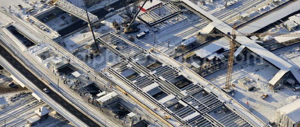 Berlin from the bird's eye view: Winterlich verschneiter Blick auf den Um- und Neubau des Berliner S-Bahnhof Ostkreuz der Deutschen Bahn. Teile der Neubauten führt die EUROVIA Beton GmbH aus. Weiterhin beteiligt ist das Unternehmen VEPRO Verkehrsbauprojekt GmbH. Upgrading and construction of the Berlin S-Bahn station Ostkreuz.