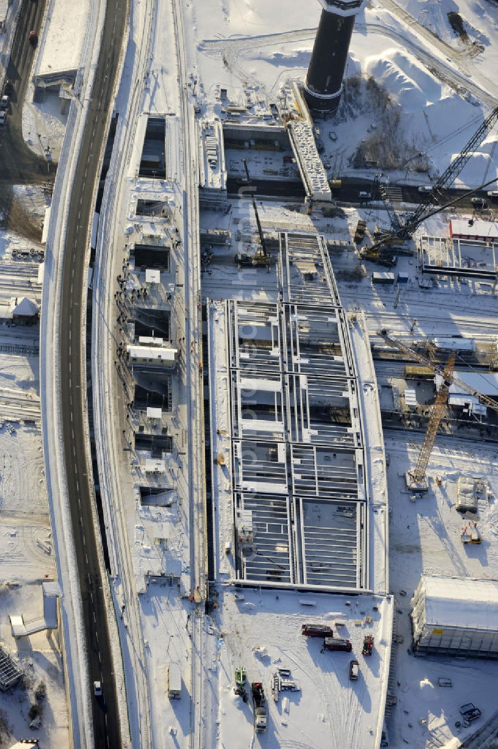 Berlin from the bird's eye view: Winterlich verschneiter Blick auf den Um- und Neubau des Berliner S-Bahnhof Ostkreuz der Deutschen Bahn. Teile der Neubauten führt die EUROVIA Beton GmbH aus. Weiterhin beteiligt ist das Unternehmen VEPRO Verkehrsbauprojekt GmbH. Upgrading and construction of the Berlin S-Bahn station Ostkreuz.