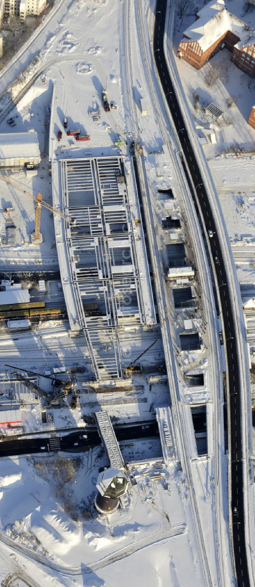 Berlin from the bird's eye view: Winterlich verschneiter Blick auf den Um- und Neubau des Berliner S-Bahnhof Ostkreuz der Deutschen Bahn. Teile der Neubauten führt die EUROVIA Beton GmbH aus. Weiterhin beteiligt ist das Unternehmen VEPRO Verkehrsbauprojekt GmbH. Upgrading and construction of the Berlin S-Bahn station Ostkreuz.