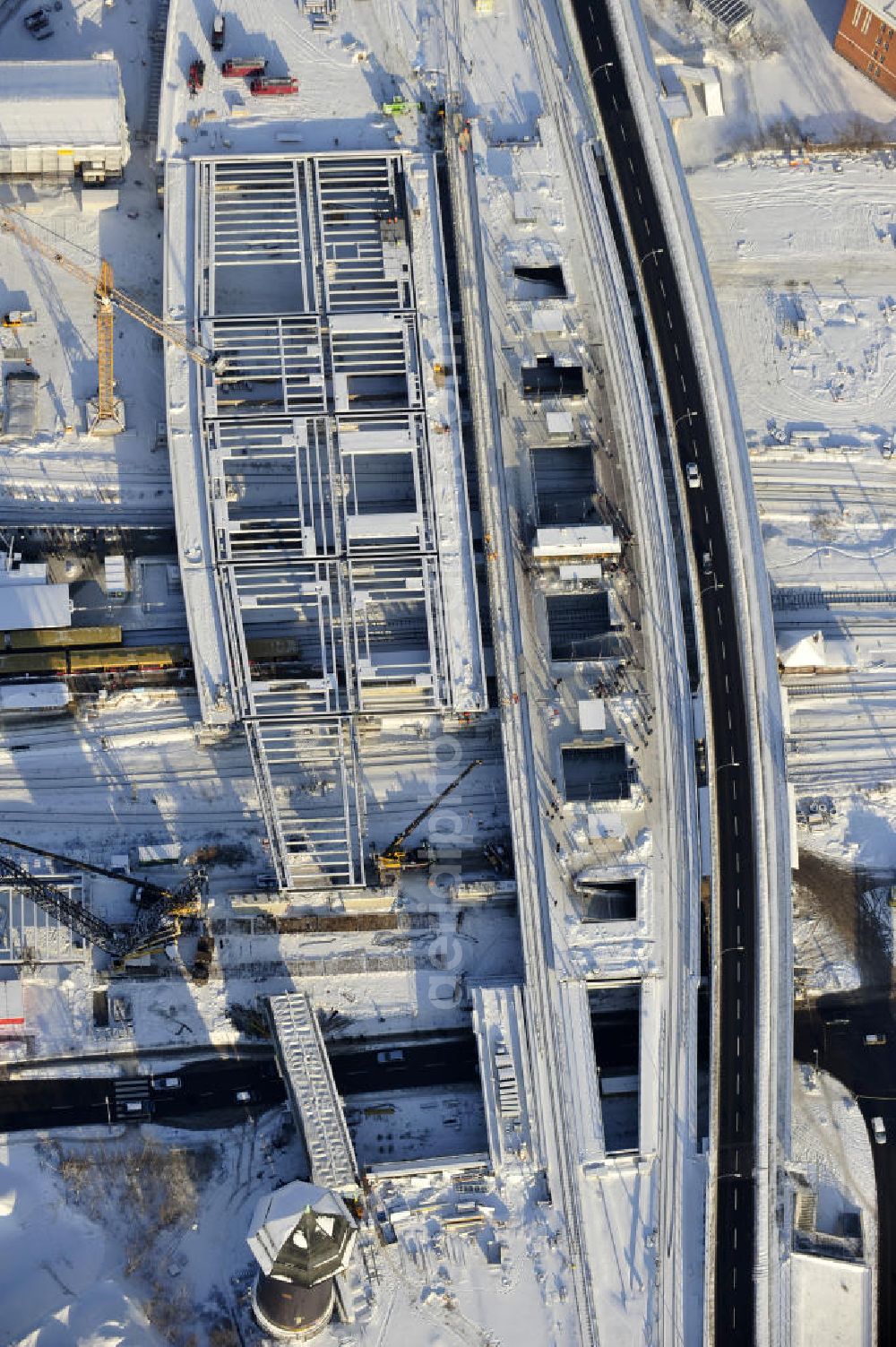 Aerial image Berlin - Winterlich verschneiter Blick auf den Um- und Neubau des Berliner S-Bahnhof Ostkreuz der Deutschen Bahn. Teile der Neubauten führt die EUROVIA Beton GmbH aus. Weiterhin beteiligt ist das Unternehmen VEPRO Verkehrsbauprojekt GmbH. Upgrading and construction of the Berlin S-Bahn station Ostkreuz.