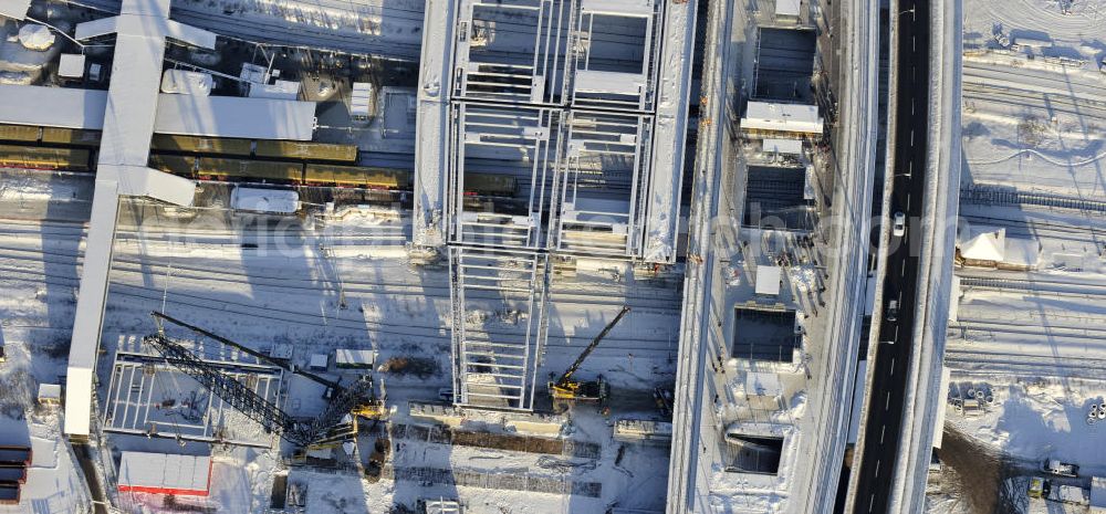 Berlin from the bird's eye view: Winterlich verschneiter Blick auf den Um- und Neubau des Berliner S-Bahnhof Ostkreuz der Deutschen Bahn. Teile der Neubauten führt die EUROVIA Beton GmbH aus. Weiterhin beteiligt ist das Unternehmen VEPRO Verkehrsbauprojekt GmbH. Upgrading and construction of the Berlin S-Bahn station Ostkreuz.