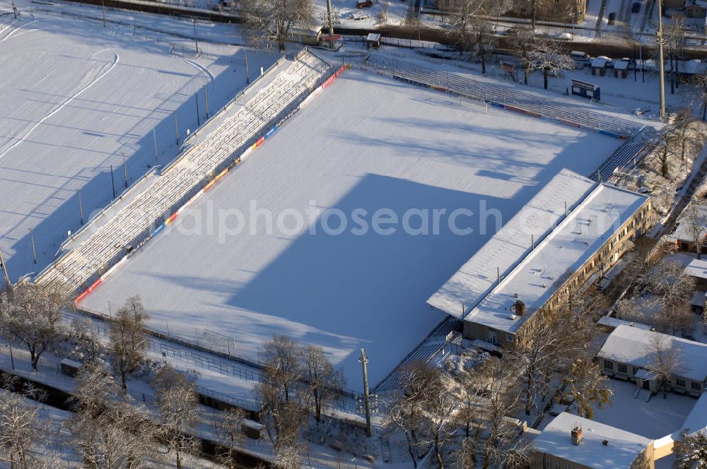 Potsdam Babelsberg from above - Blick auf das winterlich verschneite Das Karl-Liebknecht-Stadion (kurz: KarLi) ist ein Fußballstadion im Potsdamer Stadtteil Babelsberg. Es dient als Heimspielstätte das SV Babelsberg 03 sowie des 1. FFC Turbine Potsdam. Die Spielstätte befindet sich im Norden des Potsdamer Stadtteils Babelsberg. Begrenzt wird sie im Westen und Norden durch die Allee nach Glienicke und den sich daran anschließenden Park Babelsberg, im Osten durch die Karl-Liebknecht-Straße und im Süden durch ein Wohngebiet. Neben dem eigentlichen Hauptstadion befinden sich noch zwei weitere Trainingsplätze auf dem Stadiongelände. Anfang der 1970er Jahre bildete sich die Initiative zum Bau eines neuen Stadions, der in den Jahren 1974/1975 auch realisiert wurde. Am 10. Juli 1976 wurde das neue Karl-Liebknecht-Stadion offiziell mit der Partie der Fußballolympiaauswahl der DDR gegen die BSG Motor Babelsberg eingeweiht. Die Zuschauerkapazität betrug damals noch 15.000 Plätze. Sie wurde nur ein einziges mal vollkommen ausgenutzt, nämlich beim Weltmeisterschafts-Qualifikationsspiel zwischen der DDR und Malta 1977, was auch heute noch der offizielle Zuschauerrekord ist. Im Jahr 2002 wurde das Stadion gründlich saniert und mit einer in Deutschland einzigartigen Flutlichtanlage bundesligatauglich gemacht. Die Flutlichtmasten können nach Spielende eingeklappt werden, um so die Sichtachse vom Flatowturm auf die Stadt nicht zu behindern, da der angrenzende Babelsberger Park zum Weltkulturerbe gehört. Die Kapazität sank durch diese Umbaumaßnahmen auf 9.254 Zuschauer, stieg durch neue Auszählungen der Plätze dann aber wieder auf 10.499. http://