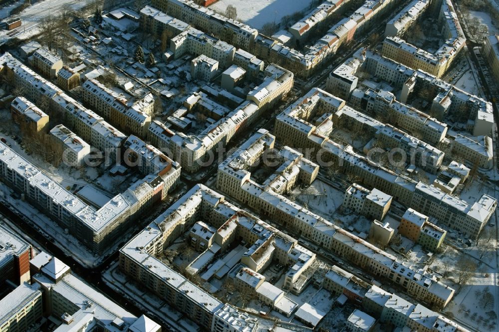 Aerial image Berlin - Winterly snowy residential area of a multi-family house settlement Strassen Schreiberhauer Strasse , Pfarrstrasse , Kaskelstrasse und Spittastrasse in Berlin in Germany