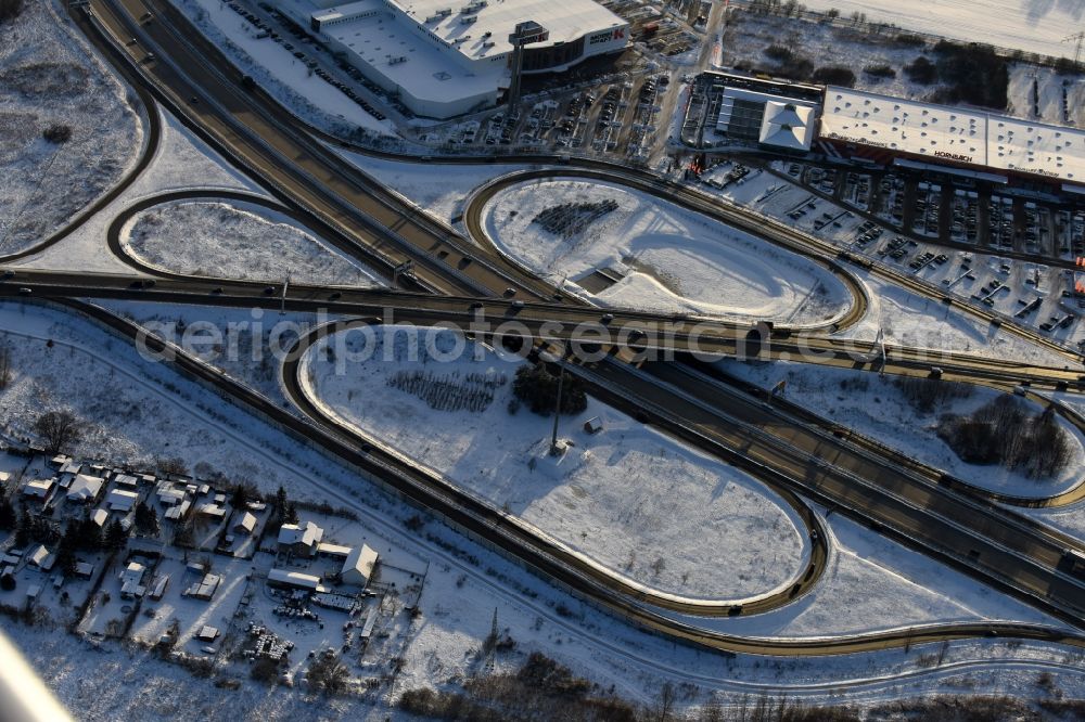 Fredersdorf-Vogelsdorf from the bird's eye view: Wintry snowy routing and traffic lanes during the highway exit and access the motorway A 10 - Bundesstrasse B1 in the district Fredersdorf in Fredersdorf-Vogelsdorf in the state Brandenburg